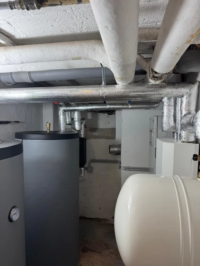 Pufferspeicher mit Manometer und gedämmte Verteilleitungen unter der Kellerdecke